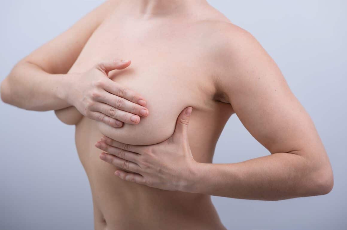 A woman with her hands on her breasts.